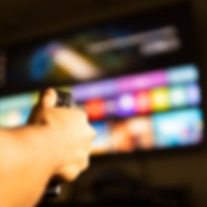 A remote pointed at a TV showing a streaming menu