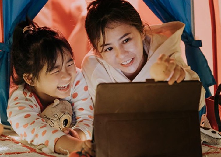 A mother and daughter watching a tablet together at home